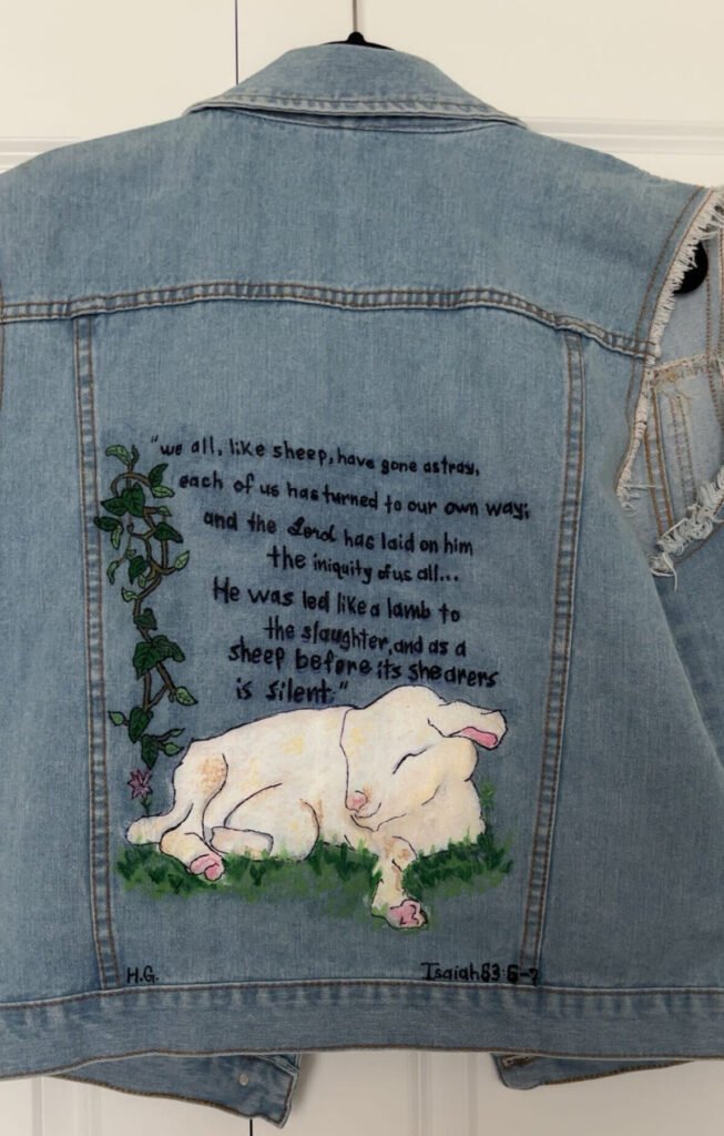 Denim jacket featuring a hand-painted lamb on grass on the back.